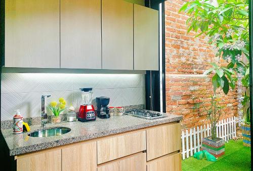 a kitchen counter with a sink and a brick wall at Loft ejecutivo con Aire Acondicionado, cerca de Clinica Duarte y UFPS in Cúcuta