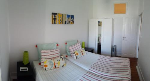 a white bedroom with a bed with two pillows at Stay Home Lisbon in Lisbon