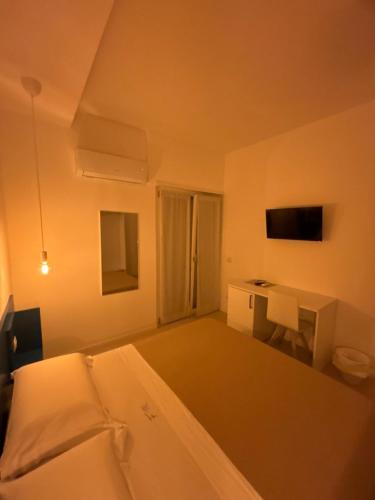 a white room with a bed and a desk at Fata Morgana Guest Rooms in Diamante