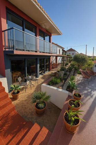 a house with a patio with potted plants at Victoria Ocean View Room in Ponta do Pargo