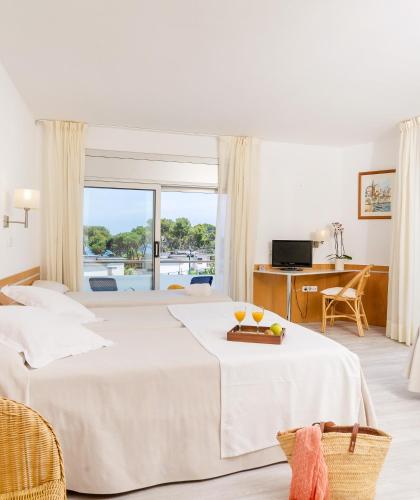 a hotel room with a bed and a window at Hotel Ancora in Palamós