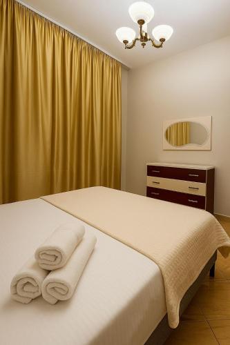 a bedroom with a bed with towels on it at Trumpets Apartment in Tirana