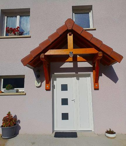 ヴィレ・ル・ラックにあるBelle îleの家の木製の屋根が付いたガレージのドア