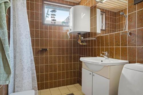 a bathroom with a sink and a toilet and a window at 30486-Odder-Kirkeager-5 in Odder