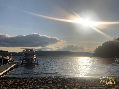 a boat is docked at a dock on a lake at Front LAKE Simon HOT TUB 6br 17p BEACH private in Lac-Simon