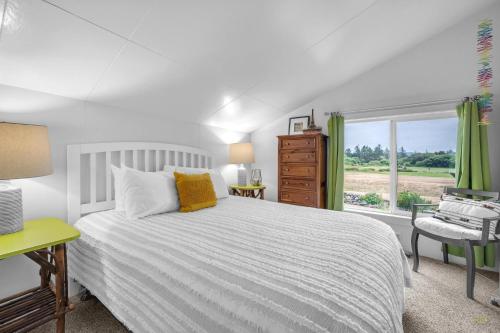a bedroom with a white bed and a window at Seaside Cove Vue in Seaside