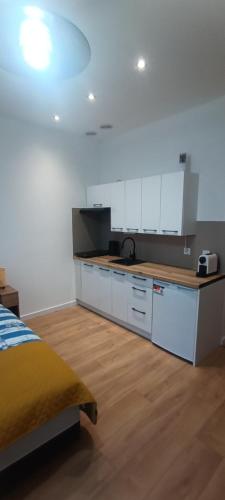 a kitchen with white cabinets and a counter top at Studio przy Szpitalu in Szczecin