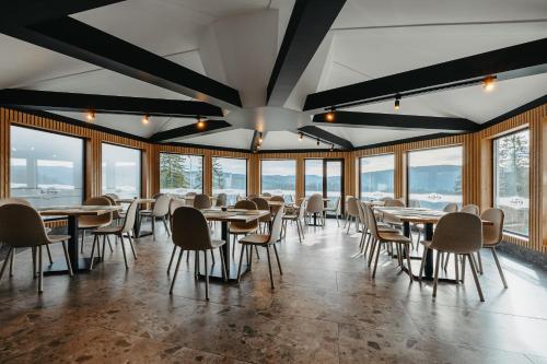 een eetkamer met tafels, stoelen en ramen bij Barka in Borsec