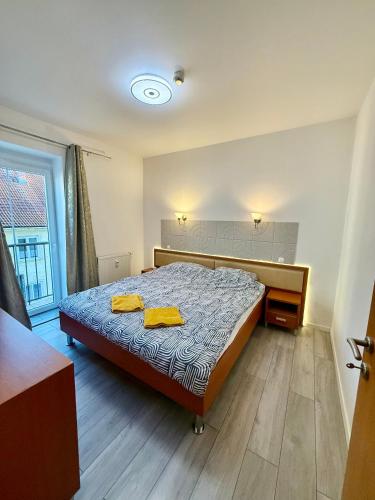 a bedroom with a bed with two yellow towels on it at Aura centrum in Piešťany