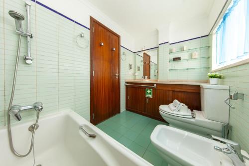a bathroom with a tub and a toilet and a sink at B28 - Stylish Typical House in Lagos
