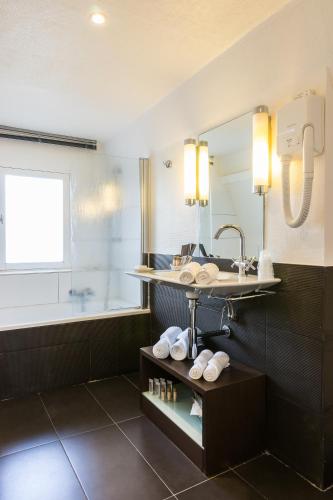 une salle de bain avec un lavabo et un miroir dans l'établissement Villa 81, à Deauville