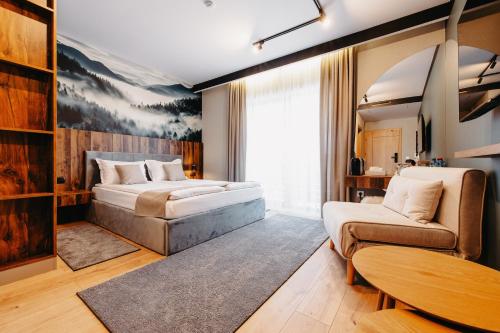 een slaapkamer met een bed, een bank en een tafel bij Barka in Borsec