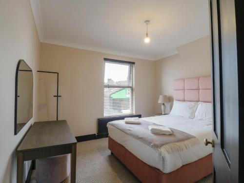 een slaapkamer met een bed, een bureau en een spiegel bij Seibiant in Ramsgate