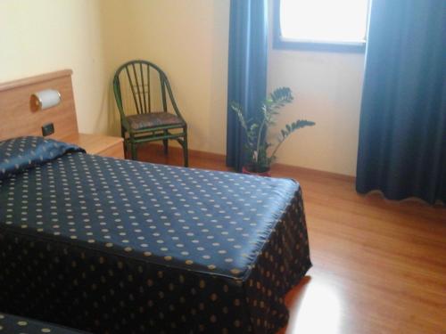 a bedroom with a bed and a chair and a window at Ca' Del Bosco in Budòio