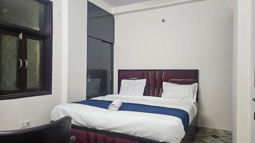een slaapkamer met een groot bed met witte en blauwe lakens bij Hotel Glass Castle Near Yashobhoomi in New Delhi