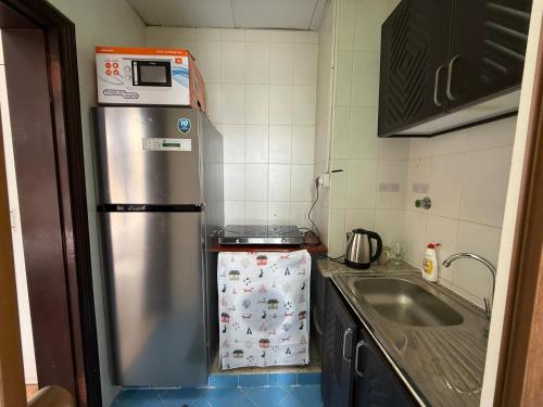 a kitchen with a stainless steel refrigerator and a sink at استديو لك بالكامل in Abu Dhabi