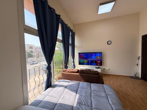 a bedroom with a bed and a large window at استديو لك بالكامل in Abu Dhabi