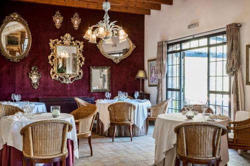 une salle à manger avec tables et chaises et un lustre dans l'établissement Hotel Rural S'Olivaret & Spa, à Alaró