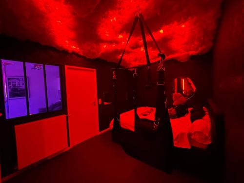 ein dunkler Raum mit roten und blauen Lichtern an der Decke in der Unterkunft Love room - La Parenthèse Douceur in Noisy-le-Grand