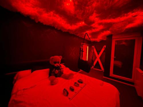 ein rotes Zimmer mit einem Bett mit roter Decke in der Unterkunft Love room - La Parenthèse Douceur in Noisy-le-Grand