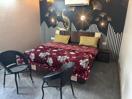 a bedroom with a bed with a red bedspread and two chairs at The Starlight Farm- Poolside Tent Stay in Jaipur in Jāmb