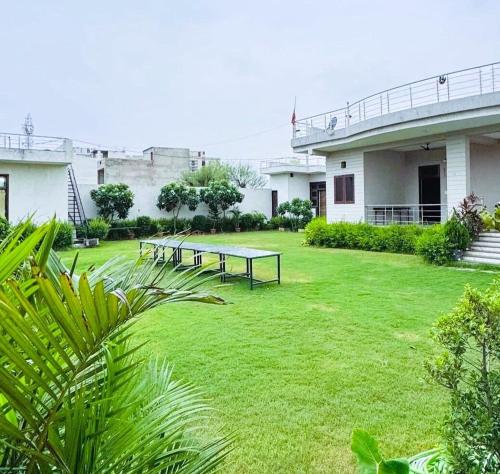 a group of picnic tables in the yard of a building at The Starlight Farm- Poolside Tent Stay in Jaipur in Jāmb