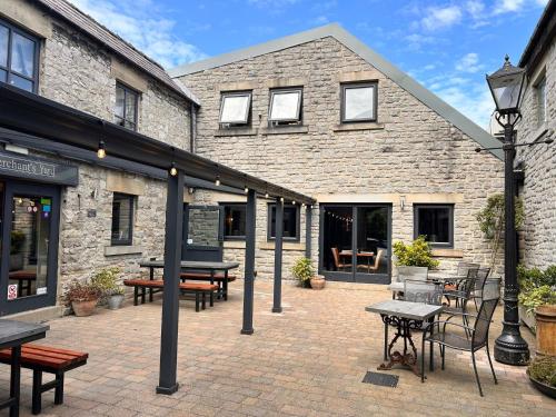 a patio with tables and benches in front of a building at The Merchant's Yard in Tideswell