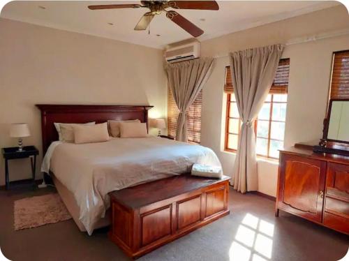 a bedroom with a bed and a ceiling fan at Khalila's Equestrian Cottage in Midrand
