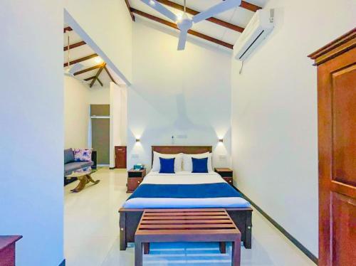 a bedroom with a bed and a bench in it at Downsouth Cabanas in Habaraduwa