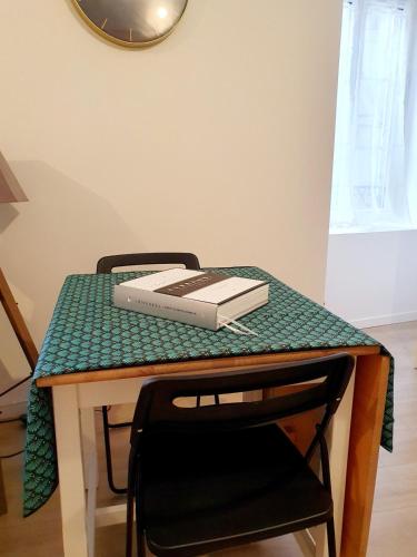 ein Tisch mit einem Buch darauf in der Unterkunft Appartement Saint Martin in Ussel