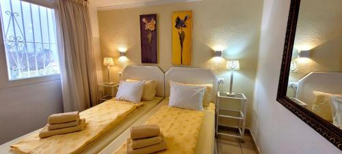 een kleine kamer met twee bedden en een spiegel bij Appartement Estaño in La Caleta