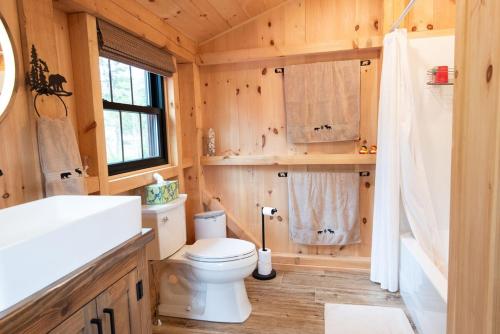 Un baño de madera con inodoro y lavabo. en Oceanview Barnhouse Retreat with Hot Tub, en Steuben