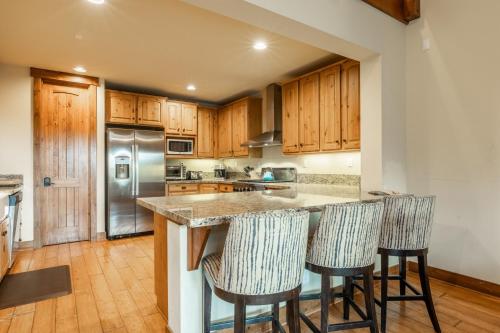 una cucina con armadi in legno e un'isola con sgabelli da bar di Lodges 1178 - Timber Lodge Retreat a Old Mammoth