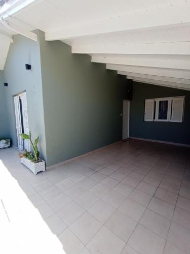 an empty room with green walls and a white tile floor at Casa a 2 cuadras del mar en Necochea in Necochea