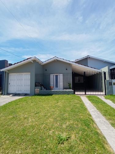 a house with a grass yard in front of it at Casa a 2 cuadras del mar en Necochea in Necochea