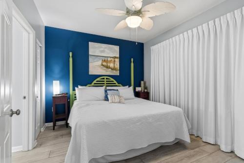 a blue bedroom with a bed and a ceiling fan at Beach Club unit 502C- Catalina in Gulf Highlands
