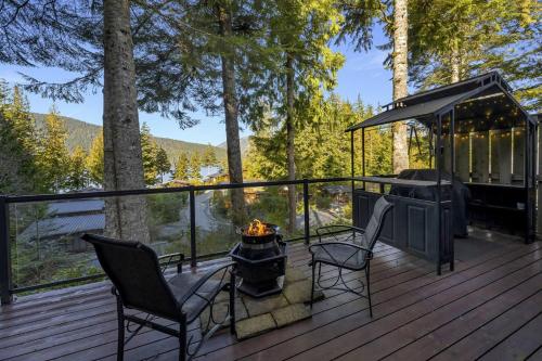 een terras met open haard, stoelen en een grill bij The Great Escape - Port Renfrew & Bunkhouse in Port Renfrew