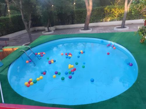 einen Pool mit bunten Bällen im Wasser in der Unterkunft Oasi Villa Anthea in Santa Lucia