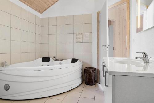 een witte badkamer met een bad en een wastafel bij 30460-Odder-Strandvaenget-16 in Odder