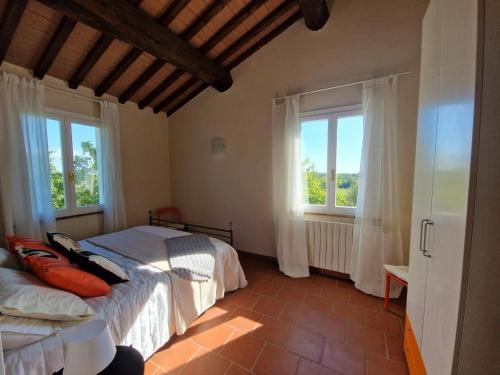 CollemezzanoにあるPiccolo Paradiso - Riparbellaのベッドが2つと窓が2つある寝室