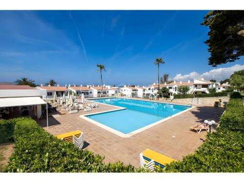 a large swimming pool with chairs and palm trees at Safir in Son Bou