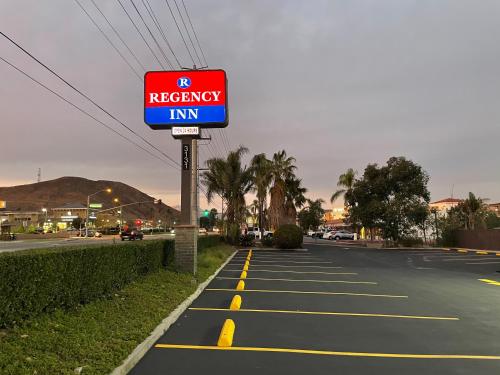 a red recovery inn sign on the side of a road at Regency Inn in Norco