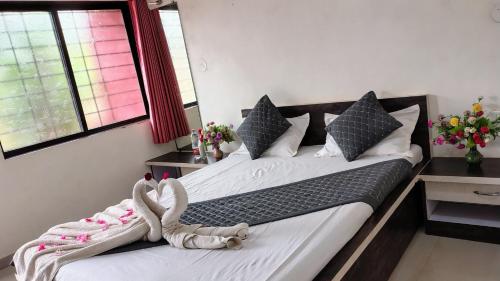 a bedroom with two beds with a stuffed animal on them at Stay Classy Inn in Mahabaleshwar