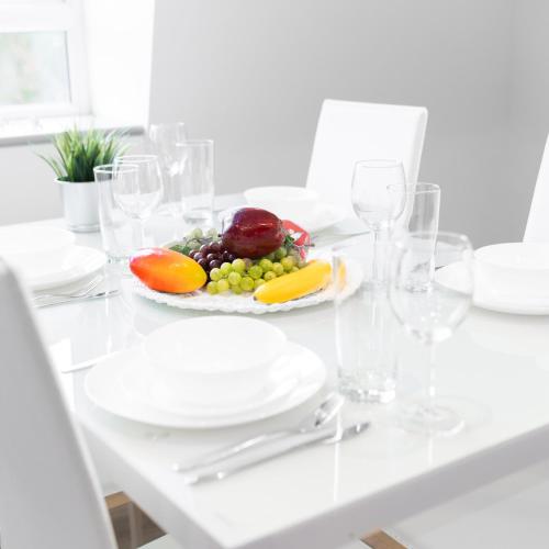 a white table with a plate of fruit and wine glasses at Modern Two Bed Apartment - Balcony & Parking - Netflix 8MC in Birmingham
