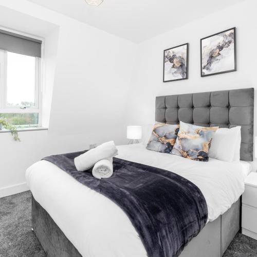 a white bedroom with a large bed with a black headboard at Modern Two Bed Apartment - Balcony & Parking - Netflix 8MC in Birmingham