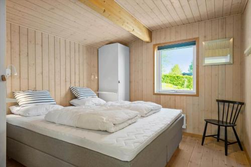 a bedroom with a large bed and a window at 30459-Odder-Solskraenten-2 in Odder