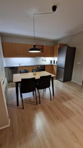 a kitchen with a table and chairs and a refrigerator at Cosy apartment Central Kopavogur in Reykjavík
