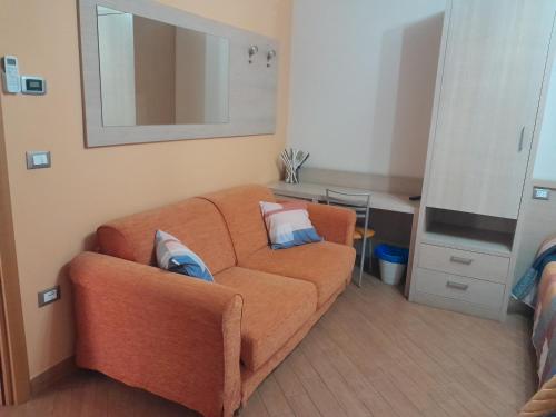 a living room with an orange couch with pillows on it at Affittacamere Certe Notti in Sala Consilina