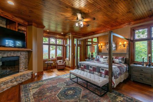 a bedroom with a canopy bed and a fireplace at Overlook Estate in The Farm in Banner Elk
