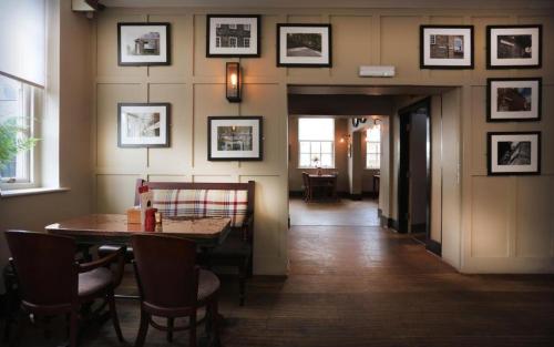 a dining room with a table and chairs and pictures on the wall at The Mitre Inn in Knaresborough